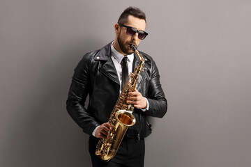 Man in a leather jacket playing a saxophone