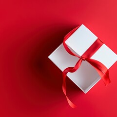 Red gift box with white ribbon on plain bright background