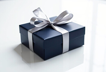 Obraz premium Luxury navy blue gift box with silver ribbon on white background perfect for birthday anniversary wedding or holiday celebrations gift giving surprise present special occasion packaging elegant gift