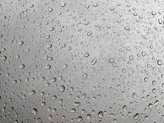 Water drops on the glass, rain is pouring through the window, beautiful droplets.