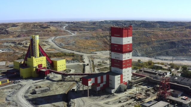 Aerial view of a modern mining facility with red and yellow structures and landscape. Stock Clip - Powered by Adobe