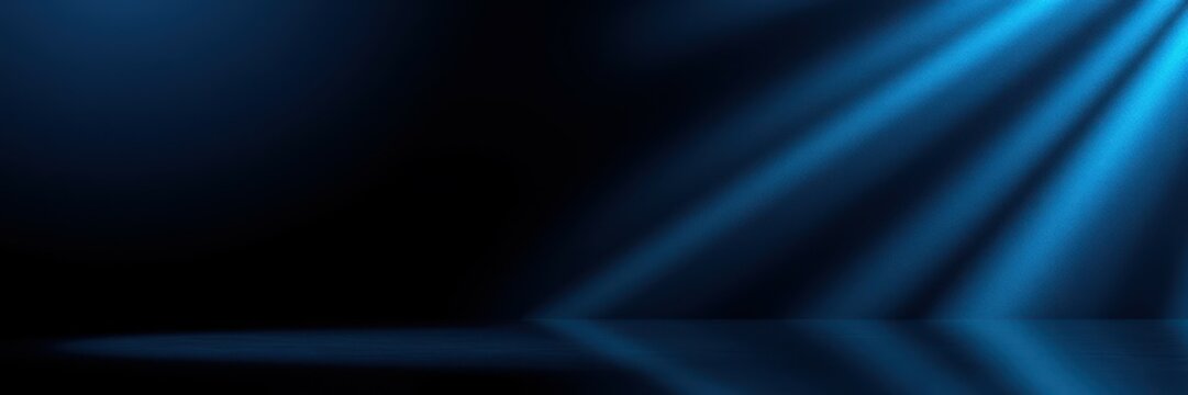 Bright blue beams of light create an abstract pattern in a dark space during a performance or event