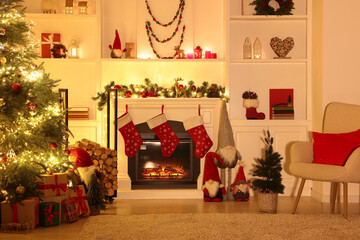 Stylish fireplace, Christmas tree with festive decor and presents indoors