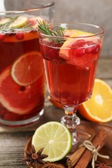 Aromatic punch drink, fresh fruits and spices on wooden table, closeup