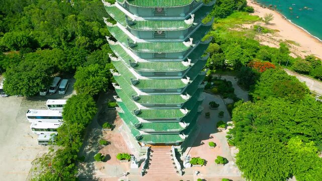 The stunning Thap Xa Loi temple, a prominent Buddhist site in Da Nang, showcases intricate architecture against a lush green backdrop and serene coastal waters.