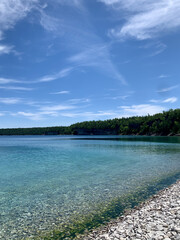 Clear blue water on cobblestone beach 