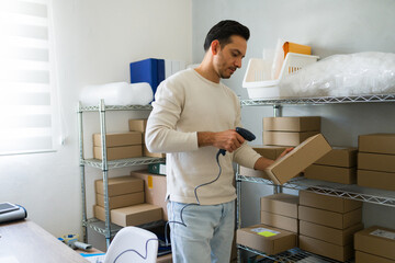 Entrepreneur in latin america using barcode scanner to handle packages and inventory in a small...
