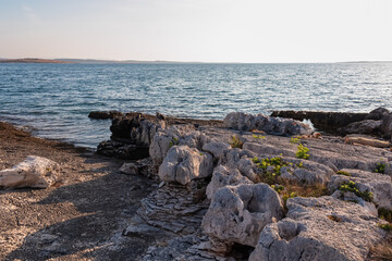 Rocky shoreline along idyllic Cape Kamenjak National Park near Premantura, Istria, Croatia. Calm waters of Adriatic Mediterranean Sea. Summer seaside travel destination. Tranquil peaceful atmosphere