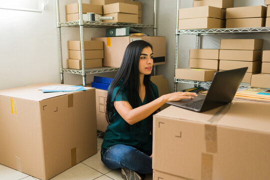 Young entrepreneur overseeing inventory and shipping in a storage room filled with packages for her online store. Emphasizing sales and marketing in the online retail industry