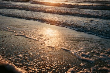 Sunlight reflecting on beach waves and sand