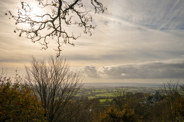 View of the English countryside near Shaftesbury, Dorset with fields, trees, hills and a church.
