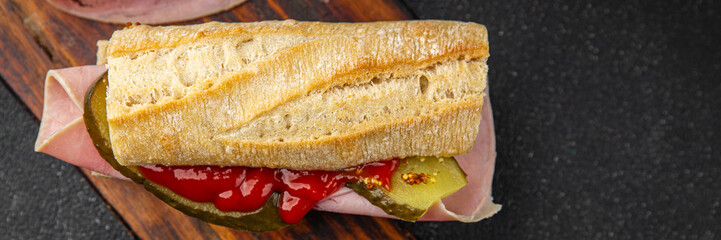 Sandwich ham, baguette, pickle cucumber, tomato sauce, mustard fast food fresh tasty food dish delicious gourmet food background on the table rustic food top view copy space