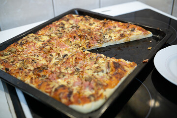 Sliced homemade pizza in a baking pan