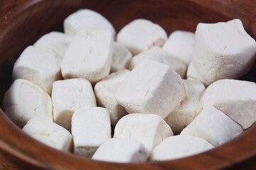 Marshmallows background. Macro photo of white marshmallows in a wooden bowl.