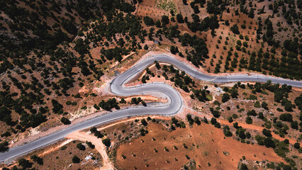 A winding mountain road captured from above. A breathtaking yet dangerous path through the peaks.