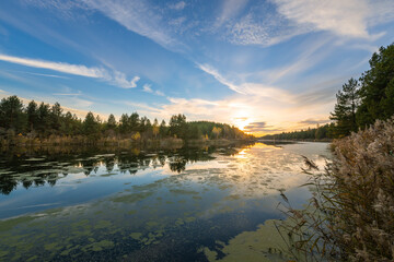 A lake with a beautiful blue sky in the background