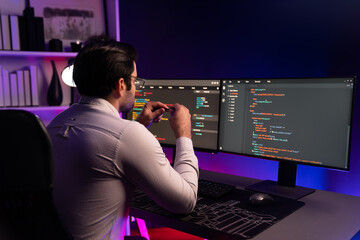 Working smart IT developer analyzing data software development on two pc screen, creating...