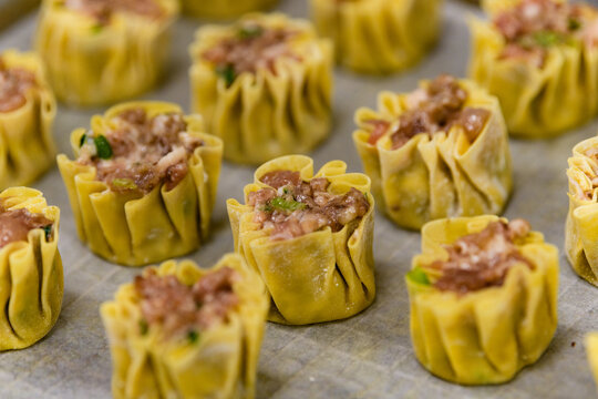 Rows of pork shumai dumplings in a kitchen