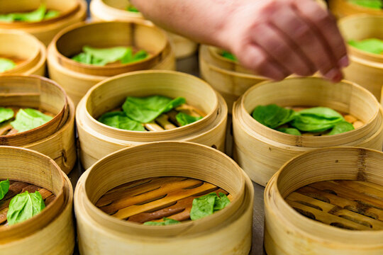 Maria Perez prepping bamboo steamers called xiaolong  in the kitchen