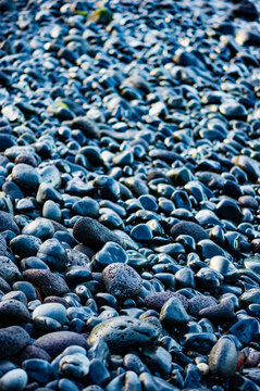 Smooth wet cobblestones on a beach in Maui