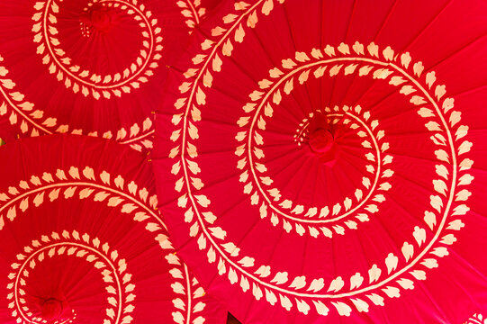Three spiral-patterned Chinese style red umbrellas at a wedding celebration, seen from above