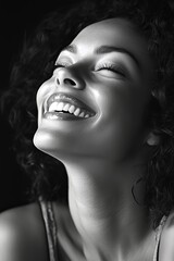 Smiling Woman With Curly Hair Enjoying a Joyful Moment of Happiness in Black and White Portrait