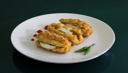 Golden Pastel Egg Filling with Chili on White Plate Close Up Indonesian Traditional Snack