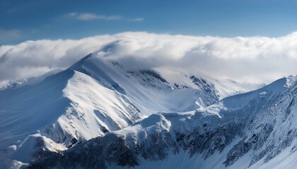 Fototapeta premium 산봉우리 위로 하얀 눈과 함께 흐릿하게 드리운 구름