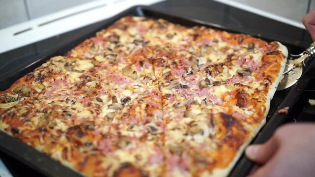 Woman's hand cutting pizza with pizza cutter wheel