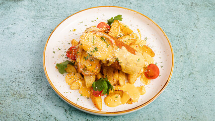 Roasted potatoes and Kyiv cutlet sliced on plate
