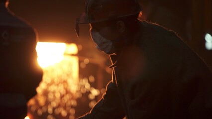 An Industrial Worker Dressed in Protective Gear at a Metal Foundry Engaged in Vital Tasks. Stock...