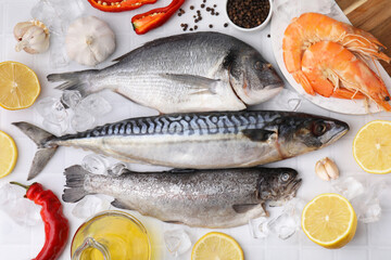 Fresh raw sea food and products on white tiled table, flat lay