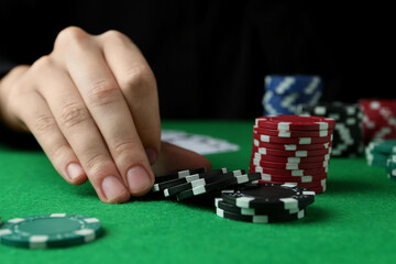 Naklejka premium Woman with poker chips at green table, closeup
