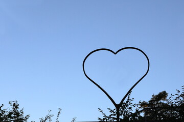 Large heart symbol in nature. Blue sky as background.