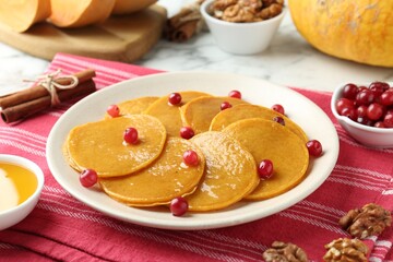 Tasty pumpkin pancakes served on white table