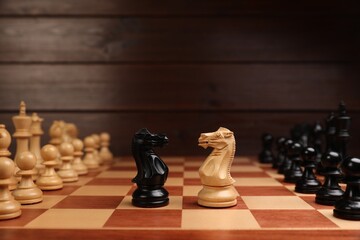 Black and white chess knights in middle of chessboard. Competition concept © New Africa