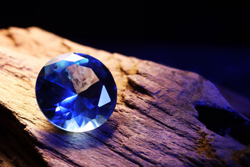 Beautiful shiny light blue gemstone on stone against dark background, closeup