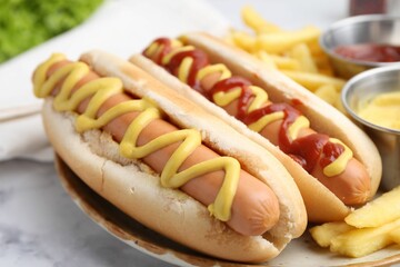 Tasty hot dogs with fries on white marble table, closeup