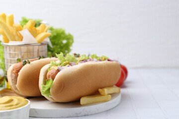 Tasty hot dogs served on white tiled table. Space for text