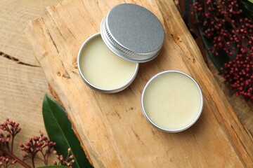 Natural solid perfume and skimmia plant on wood, top view