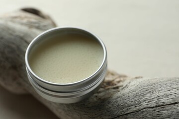 Natural solid perfume in container and snag on white table, closeup