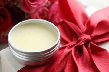 Natural solid perfume in container, gift box and flowers on table, closeup
