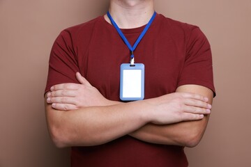 Man with blank badge on brown background, closeup