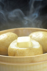 湯気が立ち昇る蒸籠でじゃがバター調理する