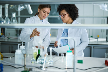 Two biochemists working with chemical substances in laboratory.
