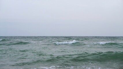 A Tranquil and Calm Seascape Scene Beneath Overcast and Cloudy Skies and Horizons