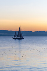 Obraz premium Sailboat Silhouette on Calm Sea at Sunset in Victoria, Canada