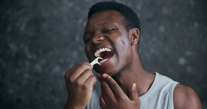 Black man, face and flossing in bathroom for dental care, grooming and gingivitis prevention. Person, oral hygiene tool or reflection POV in home for plaque control, gum cleaning or wellness in Kenya