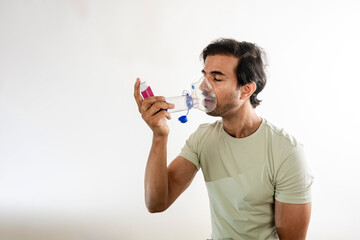 Young man using a respiratory inhaler.