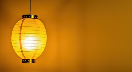 Obraz premium Yellow paper lantern with warm glow, hanging indoors